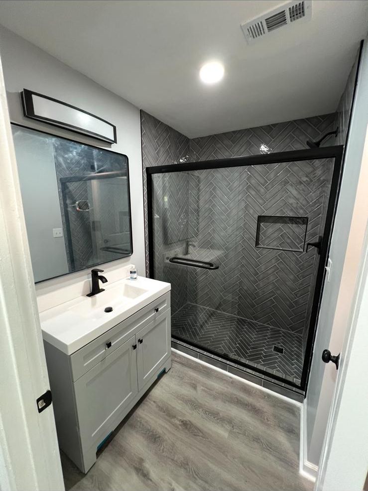 Remodeled bathroom with white vanity and glass shower