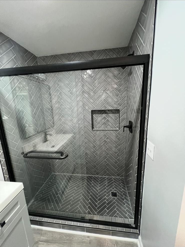 Herringbone tile shower with glass door